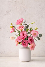 Vase With Beautiful Pink Eustoma Flowers And Eucalyptus On White Background