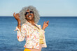 Afro-american woman with grey hair walking on sunny beach