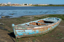 Old Artisanal Wooden Fishing Boat In A Phase Of Degradation On Top Of The Mud At Low Tide Of The Tagus River