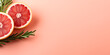 Grapefruit decorated with a twig rosemary on pink background with space for text