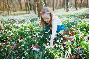 Wall Mural - Five year old girl playing egg hunt on Easter