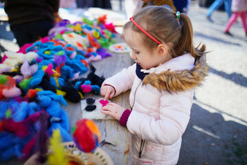 Wall Mural - Adorable preschooler girl making diy Easter craft outdoors