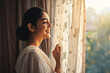 Beautiful young Indian woman open curtains look in window distance meet welcome new day at home