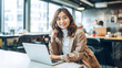 © Surachetsh - Office Working Girl, Pretty and Cute Asian Smile is sitting in front of Laptop Computer in Office Environment Background created with generative AI.