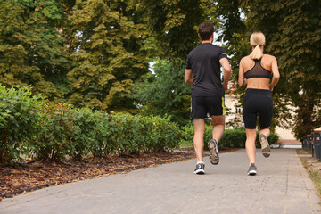 Sticker - Healthy lifestyle. Couple running in park, back view with space for text