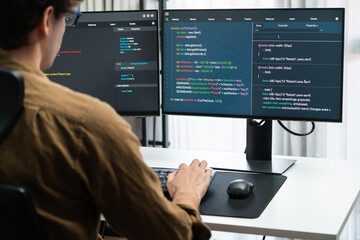 it developer working online software development on pc monitors at modern home office on coding appl