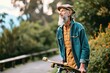 Active cool bearded old hipster man standing in nature park holding skateboard. Mature traveler skater enjoying freedom spirit and extreme sports hobby leisure lifestyle, authentic, Generative AI 