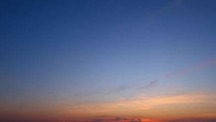 Wall Mural - Sunset sky timelapse. Vivid hues blend as day meets night in a frenzied dance, clouds rushing like spirits in the fading light. Loop footage. Time-lapse.
