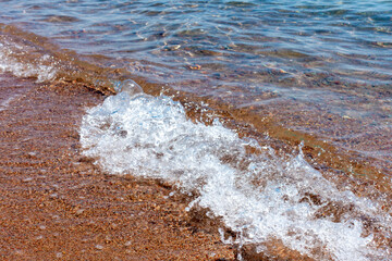 Wall Mural - Clean transparent water, wave on the sand. Coastline. Kyrgyzstan, Lake Issyk-Kul. natural background.