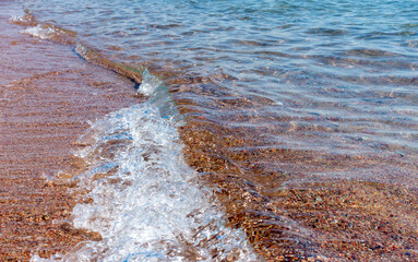 Wall Mural - Clean transparent water, wave on the sand. Coastline. Kyrgyzstan, Lake Issyk-Kul. natural background.