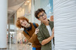 © Nomad_Soul - Two curious boys peeking out from behind column at shopping mall