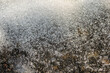 Macro shot of melting snow on black asphalt on a sunny spring day