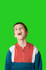 Shocked or surprised little boy keeping mouth open on green backgound