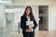 © Flamingo Images - Laughing businesswoman standing at the door of an office boardroom