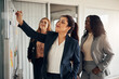 © Flamingo Images - Smiling businesswoman and her team brainstorming together on an office whiteboard