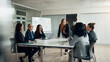 © Flamingo Images - Smiling executive and a group of businesswomen talking during a boardroom meeting