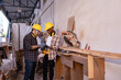 © Wanwajee - Young Affrican American and white men carpenter labor, craftman working in wood workshop together,  looking tabet together, furniture industry. with copy space