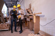 © Wanwajee - Young Affrican American and white men carpenter labor, craftman working in wood workshop together,  looking tabet together, furniture industry. with copy space