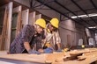© Wanwajee - Young affrican american and white men carpenter labor, craftman working in wood workshop together, talking. Timber industry and furniture industry.