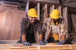 © Wanwajee - Young affrican american and white men carpenter labor, craftman working in wood workshop together, looking. Timber industry and furniture industry.
