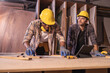 © Wanwajee - Young affrican american and white man carpenter labor, craftman working in wood workshop. Timber industry and furniture industry small business concept.