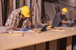 © Wanwajee - Young affrican american and white man carpenter labor, craftman working in wood workshop. Timber industry and furniture industry small business concept.