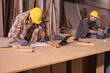 © Wanwajee - Young affrican american and white man carpenter labor, craftman working in wood workshop. Timber industry and furniture industry small business concept.