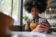 Closeup shot of young black gen z African American girl with afro hair holding cell smart phone scanning qr code to read menu or make payment online in cafe sitting at table, Generative AI  