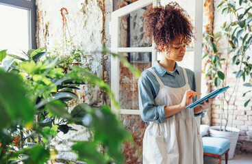 Wall Mural - Portrait of successful african american woman looking at tablet computer