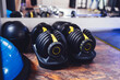 Two modern adjustable dumbbells on stands. Sports equipment in the gym.