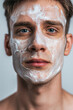 © Darya Lavinskaya - Handsome young Caucasian man with facial mask looking at camera against grey background