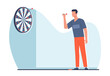 © YummyBuum - Man playing darts. Aim at target. Male character ready to throw arrow. Hobby and leisure time. Dartboard on wall. Achievement goals metaphor. Play game. Cartoon isolated vector concept