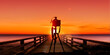 Fotokamera mit Stativ vor einem Sonnenuntergang am Meer