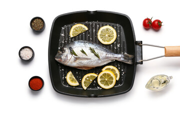 Wall Mural - Grill pan of raw dorado fish with lemon and spices and on white background