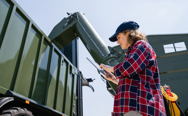 Poster - Woman farmer with tablet watching grain loading