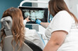 © YURIMA - The dentist shows the patient a panoramic X-ray on the monitor, carefully explaining all the details and features of her dental condition. A dentist with great professionalism shows the patient a