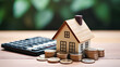 © Mongkol - Home finance, showcasing a house model, calculator, and coins, ideal for illustrating investment and mortgage concepts in real estate.