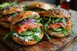 © losmostachos - Bagel bread stuffed with salmon purple onion, arugula, avocado, cucumber and cream cheese. on a cutting board