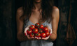 Zdjęcie kobiety ze świeżymi pomidorami w dłoniach, zbliżenie na same dłonie