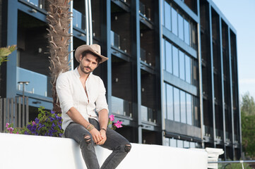 Handsome man fashion portrait dressed in straw hat and white shirt