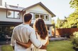 © Dara - Shot from behind of Happy young couple standing in front of new home