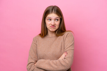 Teenager Russian girl isolated on pink background making doubts gesture while lifting the shoulders