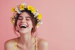 Cheerful girl in wreath of bright flowers on pink background. Portrait of a beautiful woman in spring or summer. Concept of beauty and tenderness. Girl with natural makeup. Banner with copy space