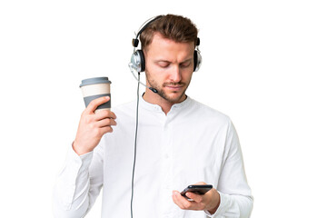 Wall Mural - Telemarketer caucasian man working with a headset over isolated chroma key background holding coffee to take away and a mobile