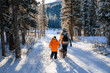 © josev82 - Mother and son walking their dog in a snowy forest on a wintry morning in Alberta, Canada