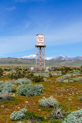 Desert Hot Springs, California water tower centered in frame with snow capped San Gorgonio Mountains in the background. Shot vertically.