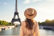© Ifti Digital - A woman stands in front of the iconic Eiffel Tower in Paris, France, tourist woman in summer dress and hat standing on beautiful sandy beach, AI Generated