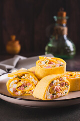 Poster - Tortilla rolls with salad of sausages, eggs, cheese and herbs on a plate vertical view