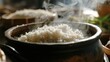  a pot filled with white rice sitting on top of a table next to a pot with steam coming out of it.
