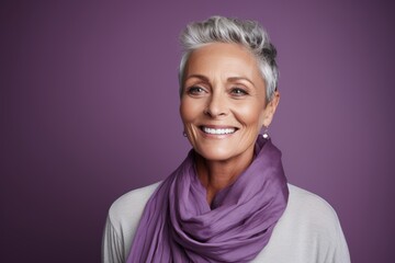 Wall Mural - Portrait of a happy senior woman with purple scarf over purple background